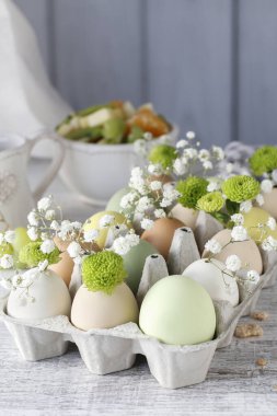 İşteki çiçekçi: Sıradan bir karton yumurta kutusu, kasımpatı santinisi, alçıpan dalları ve yosunlarla nasıl basit bir Paskalya çiçeği aranjmanı yapılır. Adım adım, öğretici.