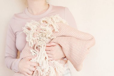 Genç bir kadın pembe yumuşak bir battaniye tutuyor. Uyku zamanı.