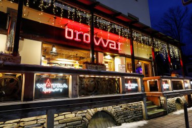 ZAKOPANE, POLAND - 3 Aralık 2024: Zakopane 'deki Krupowki Caddesi' ndeki barın gece aydınlanması. Turistler için tatil yeri