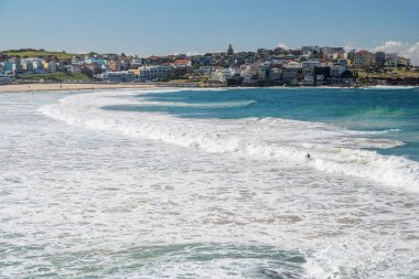 Sydney 'deki altın renkli kumlu kumlu plaj. Bondi plajı sörfçüler için mükemmel bir yer çünkü sürekli yükselen yüksek dalgalar var..