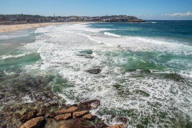 Sydney 'deki altın renkli kumlu kumlu plaj. Bondi plajı sörfçüler için mükemmel bir yer çünkü sürekli yükselen yüksek dalgalar var..