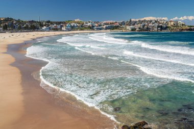 Sydney 'deki altın renkli kumlu kumlu plaj. Bondi plajı sörfçüler için mükemmel bir yer çünkü sürekli yükselen yüksek dalgalar var..