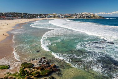 Sydney 'deki altın renkli kumlu kumlu plaj. Bondi plajı sörfçüler için mükemmel bir yer çünkü sürekli yükselen yüksek dalgalar var..