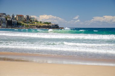 Sydney 'deki altın renkli kumlu kumlu plaj. Bondi plajı sörfçüler için mükemmel bir yer çünkü sürekli yükselen yüksek dalgalar var..