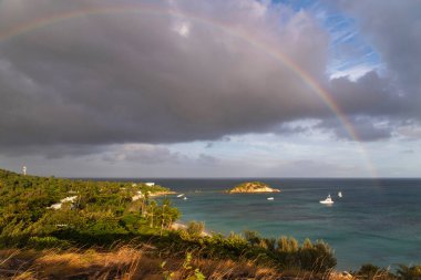 Avustralya, Queensland 'daki Kertenkele Adası' nda turkuaz suyu olan tropikal kumlu plajda gökkuşağı.