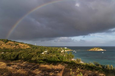 Avustralya, Queensland 'daki Kertenkele Adası' nda turkuaz suyu olan tropikal kumlu plajda gökkuşağı.