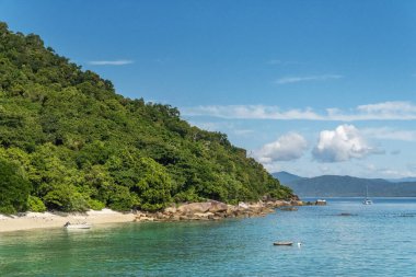 Picturesque tropical coral beach with turquoise water on Fitzroy Island. It is a continental island southeast of Cairns, Queensland, Australia. clipart