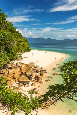 Picturesque tropical coral beach with boulders and turquoise water on Fitzroy Island. It is a continental island southeast of Cairns, Queensland, Australia. clipart