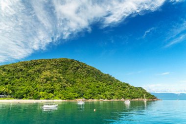 Fitzroy Adası 'nda kaya parçaları ve turkuaz su bulunan tropikal mercan plajı. Cairns, Queensland, Avustralya 'nın güneydoğusunda bir kıta adasıdır..