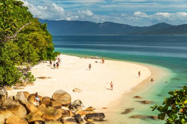 Picturesque tropical coral beach with boulders and turquoise water on Fitzroy Island. It is a continental island southeast of Cairns, Queensland, Australia. clipart