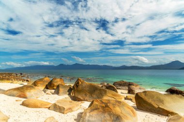 Picturesque tropical coral beach with boulders and turquoise water on Fitzroy Island. It is a continental island southeast of Cairns, Queensland, Australia. clipart