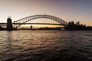 Gün batımında Sydney Limanı Köprüsü 'nde muhteşem bir manzara. Köprü 1932 'de açıldı ve dünyanın en uzun çelik kemerli köprüsü..