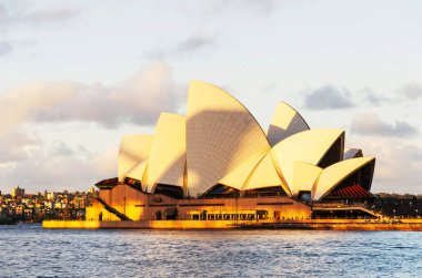 Gün batımında Sydney Opera Binası 'nın ayırt edici binası. Sidney, New South Wales, Avustralya 'daki en ünlü turistik merkezdir..