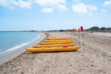 Sahilde bir sıra sarı kano sıraya dizildi. Kanolar kullanıma hazır.