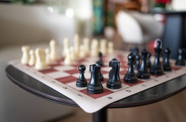 Ev ortamında satranç taşları olan satranç tahtası, oyun için hazır.