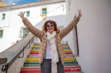 Neşeli kadın dışarıda renkli adımlarla kutlama yapıyor.