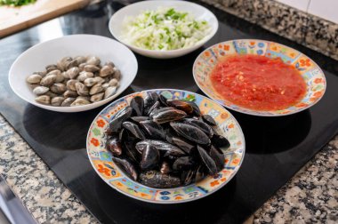 Taze midye, midye, doğranmış soğan ve domates sosu tabakta, deniz ürünleri yemeği pişirmeye hazır.