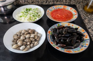 Tabaklara deniz ürünleri, midye, doğranmış sebze ve domates sosu da dahil olmak üzere bir deniz ürünleri tabağı içerir.