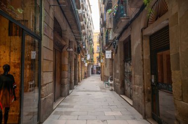 Barselona 'da turistlerin yürüdüğü dar bir cadde ve binaların arasında sarkan ip ışıkları, rahat bir atmosfer yaratıyor.