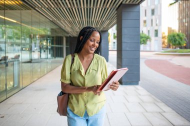 Kentsel finans bölgesinde işe giderken tablet üzerinde gezinen mutlu yönetici