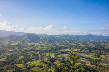 Haiti adasının yeşil dağları ve vadileri. Mavi dağlar, yeşil vadi. Yaz günü Haiti dağlarının panoramik manzarası. Turizm ve seyahat konsepti. Doğal yeşil orman arka plan panoraması.