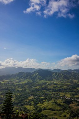 Haiti adasının yeşil dağları ve vadileri. Mavi dağlar, yeşil vadi. Yaz günü Haiti dağlarının panoramik manzarası. Turizm ve seyahat konsepti. Doğal yeşil orman arka plan panoraması.