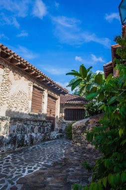 Ormanda kırmızı çatılı bir villa. Tropikal enlemlerde eski Avrupa tarzı bir ev. Vahşi doğada yaşamak. Tropiklerdeki tuğla ev. Dominik Cumhuriyeti
