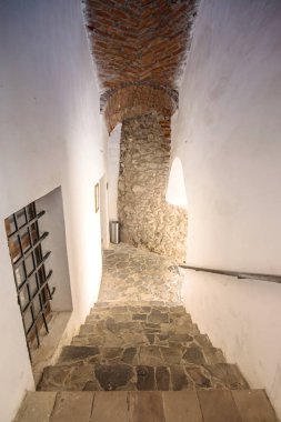 Eski şatonun iki parçası arasında eski bir taş merdiven var. Taş kemer ve kaleye adımlar. Eski şatoda merdivenleri olan taş koridor..