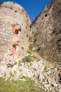 Eski bir kalenin kalesinin bir parçası. Kalenin ortasında güçlü bir kale var. Kalenin yüksek antik duvarları. Taş ve tuğla işi.