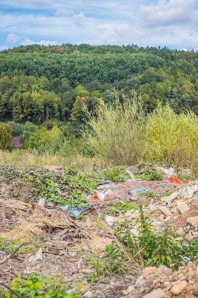 Dağlarda çöp yığını. Ormanlık dağlarda yarı gömülü bir çöp yığını. Karpatlar. Ukrayna