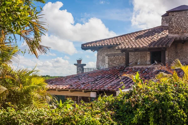 Villa with a red roof in the jungle. Old European-style house in tropical latitudes. Living in wild. Brick house in the tropics. Dominican Republic