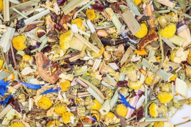 Alpine Field. Herbal tea with lemongrass, flowers and camomile on the white plate. Top view. Close up. High resolution. Alpine herbs tea as background