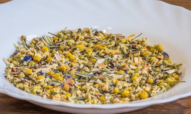 Alpine Field. Herbal tea with lemongrass, flowers and camomile on the white plate. Top view. Close up. High resolution. Alpine herbs tea as background
