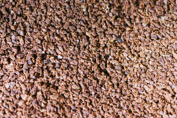 The grains of ground black coffee are very close. Close up ground coffee background. Brown coffee powder texture extreme closeup photo