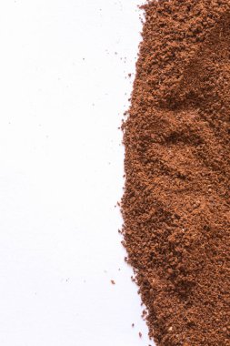 Beyaz arka planda bir yığın öğütülmüş kahve. Koyu kahve taneleri çok yakındır. Kahve arkaplanını kapat..