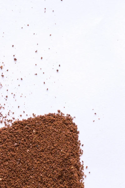 stock image A pile of scattered ground coffee on a white background. The grains of ground black coffee are very close. Close up ground coffee background.