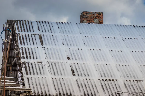 雪地里的一座私宅的屋顶 雪地里的屋顶被弄脏了 冬天的时候屋顶上覆盖着雪 部分屋顶被雪清理干净 — 图库照片