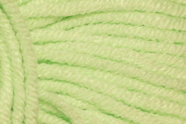The texture of the rope light green in a skein. Abstract background.A skein of light green thick thread very close
