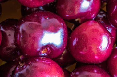 Taze kırmızı, tatlı vişneli. Siyah arka planda dönen, su damlacıklarıyla kaplı kırmızı kirazlar. Islak kirazlar siyah bir uçakta dönüyor.