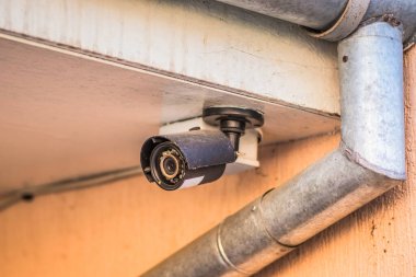 Caddedeki özel bir evin çatısından çekilmiş bir video kamera. Kameralı özel bir evin güvenliği. Bahçeyi korumak için küçük bir kamera..