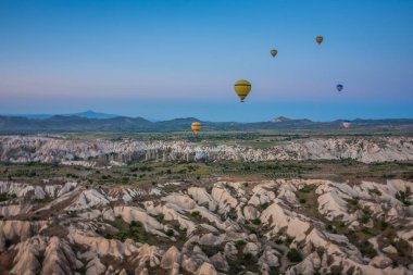 Sıcak hava balonları Kapadokya 'daki tuhaf kaya manzarasının üzerinde uçuyor. Balonlar sabah erkenden uçar. Sabah gökyüzünde güzel sıcak hava balonları. Gorme. Türkiye