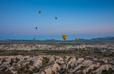 Sıcak hava balonları Kapadokya 'daki tuhaf kaya manzarasının üzerinde uçuyor. Balonlar sabah erkenden uçar. Sabah gökyüzünde güzel sıcak hava balonları. Gorme. Türkiye