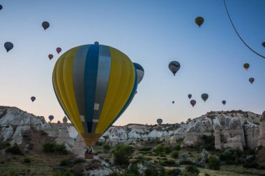 Sıcak hava balonları Kapadokya 'daki tuhaf kaya manzarasının üzerinde uçuyor. Balonlar sabah erkenden uçar. Sabah gökyüzünde güzel sıcak hava balonları. Gorme. Türkiye