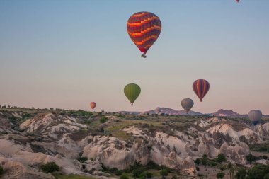 Sıcak hava balonları Kapadokya 'daki tuhaf kaya manzarasının üzerinde uçuyor. Balonlar sabah erkenden uçar. Sabah gökyüzünde güzel sıcak hava balonları. Gorme. Türkiye
