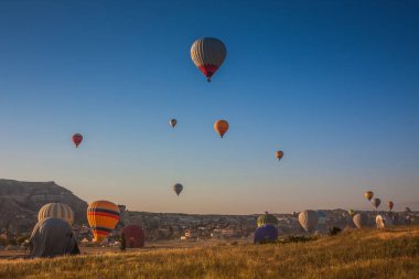 Sıcak hava balonları sabahın erken saatlerinde havalanır. Sıcak hava balonları Kapadokya 'daki tuhaf kaya manzarasının üzerinde uçuyor. Sabah gökyüzünde güzel sıcak hava balonları. Gorme. Türkiye
