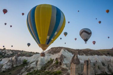Sıcak hava balonları Kapadokya 'daki tuhaf kaya manzarasının üzerinde uçuyor. Balonlar sabah erkenden uçar. Sabah gökyüzünde güzel sıcak hava balonları. Gorme. Türkiye