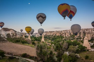 Sıcak hava balonları Kapadokya 'daki tuhaf kaya manzarasının üzerinde uçuyor. Balonlar sabah erkenden uçar. Sabah gökyüzünde güzel sıcak hava balonları. Gorme. Türkiye