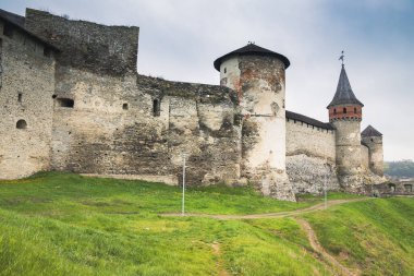 Kamianets-Podilskyi Kalesi 'nin bulutlu bir gökyüzünün altındaki kısmı. Tarihi Kamianets-Podilskyi şehrinin pitoresk doğası arasında yer alan kalenin güçlü kaleleri ve kuleleri,