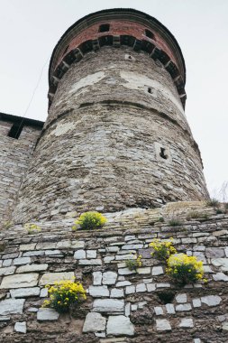 Kamianets-Podilskyi Kalesi 'nin bulutlu bir gökyüzünün altındaki kısmı. Tarihi Kamianets-Podilskyi şehrinin pitoresk doğası arasında yer alan kalenin güçlü kaleleri ve kuleleri,