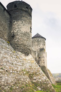 Kamianets-Podilskyi Kalesi 'nin bulutlu bir gökyüzünün altındaki kısmı. Tarihi Kamianets-Podilskyi şehrinin pitoresk doğası arasında yer alan kalenin güçlü kaleleri ve kuleleri,